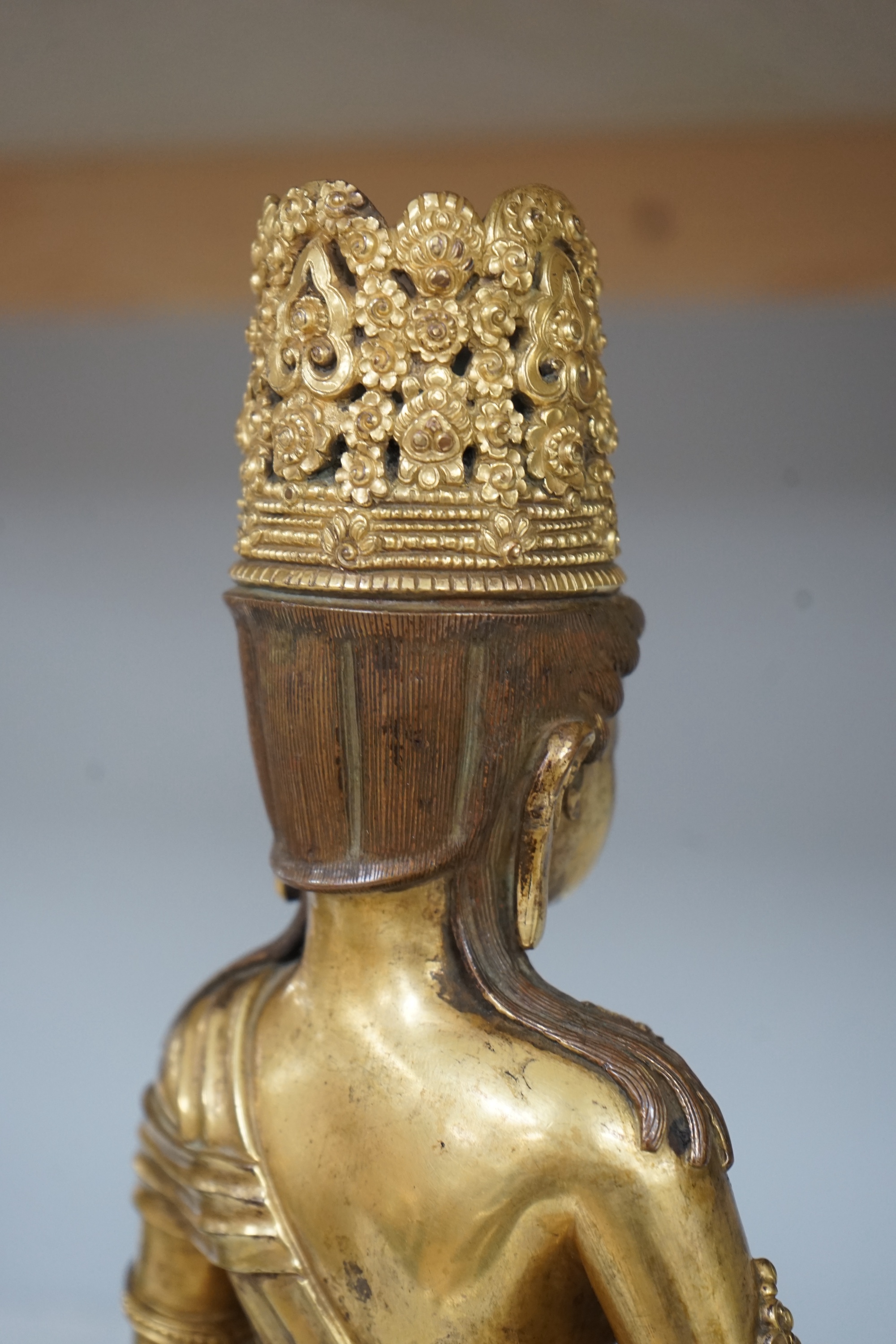 Tibetan School, 20th century gilt bronze figure of a seated deity, 31cm high. Condition - good